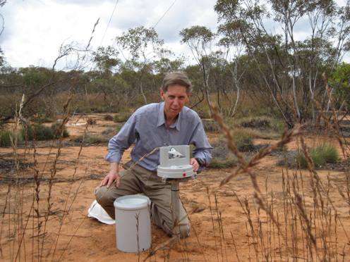 person at rain gauge