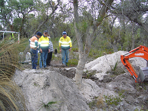 Men looking at a hole