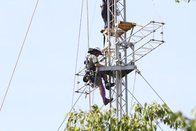 someone climbing up the mast where pantographs are mounted